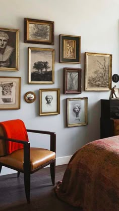 a bed room with a neatly made bed and lots of framed pictures on the wall