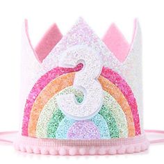 a pink and white birthday crown with the number 3 on it's side, decorated with multicolored sequins