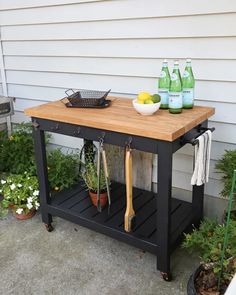 an outdoor kitchen island with bottles and utensils on it