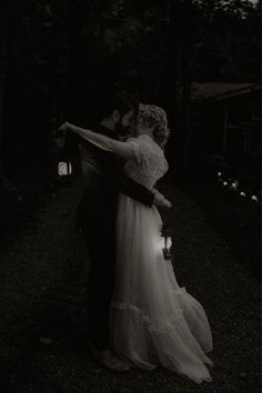 black and white photograph of a bride and groom hugging in the dark with their arms around each other