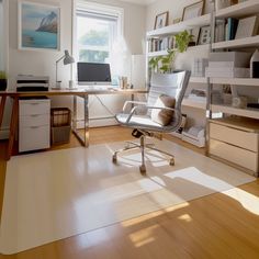 an office with a chair, desk and computer on the floor in front of a window