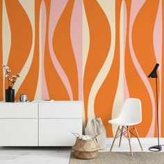 an orange and pink wallpaper in a living room with a white chair next to it