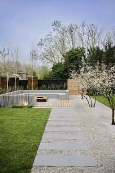 an outdoor area with stone walkways, grass and trees