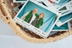 a wicker basket filled with lots of pictures and cards on top of each other