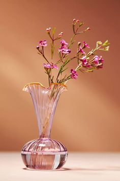 a pink vase filled with flowers on top of a table