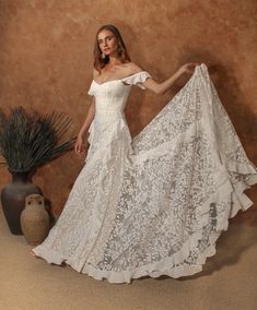 a woman in a white wedding dress posing for the camera with her hand on her hip