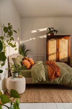 a bed sitting in a bedroom next to a wooden dresser and potted plant on top of a rug