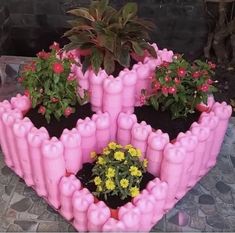 there is a pink planter with flowers in it