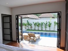 a bed sitting in a bedroom next to a sliding glass door leading to a pool