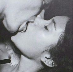 a man kissing a woman's face while she kisses her nose