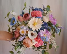 a woman holding a bouquet of flowers in her hand