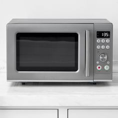 a silver microwave oven sitting on top of a counter