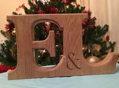 a wooden block with the letter d and an ornament on it in front of a christmas tree