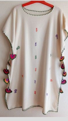 a white top with colorful embroidered designs on it