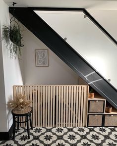 an attic space with black and white tile flooring, wooden radiator and storage boxes