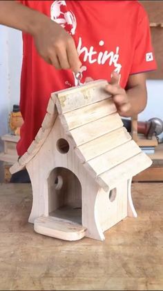 a man is making a birdhouse out of wood