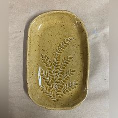 a ceramic dish with a leaf design on it