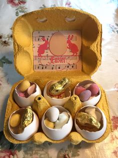 an open box filled with different types of eggs and chocolates on top of a table