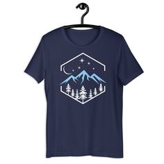 Introducing our Nature at Night T-Shirt - a wearable masterpiece that captures the serene beauty of the great outdoors in a sleek and modern design. This t-shirt is not just clothing; it's a window to tranquility, a canvas of calmness that you can carry with you wherever you go. The Nature at Night t-shirt features a striking composition of pine trees, majestic mountains, and a star-studded night sky reminiscent of the beautiful Pacific Northwest. The design embodies the essence of nature's gran Short Sleeve Graphic Print Sleep T-shirt, Short Sleeve Sleep T-shirt With Graphic Print, Short Sleeve Letter Print Sleep T-shirt, Blue Graphic Print Sleep Top, White Graphic Print Sleep T-shirt, White Short Sleeve Sleep T-shirt, Nature At Night, Mountain Trees, Mountain Tshirt