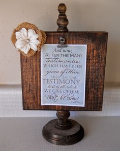 a wooden sign with a white flower on it and some words written in the frame