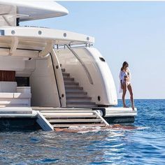 a woman is standing on the deck of a boat in the middle of the ocean