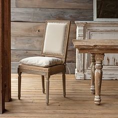 a chair and table in front of a wooden wall