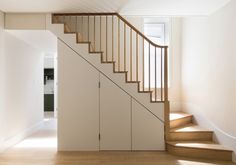 a staircase leading up to the second floor in a house with white walls and wood floors