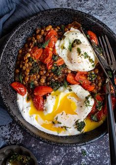 a bowl filled with eggs, beans and tomatoes