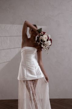 a woman in a white dress holding a bouquet