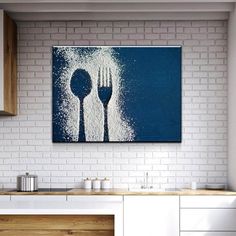 a white brick wall in a kitchen with blue and white artwork above the countertop