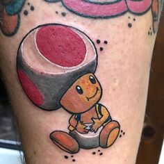 a person with a tattoo on their leg has an image of a teddy bear holding a red object