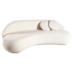 a large white couch with two pillows on it's back and one arm folded up