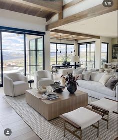 a living room filled with white furniture and large glass doors leading to an outside patio