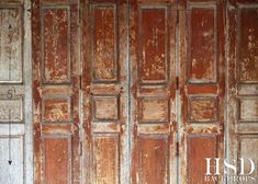 an old wood paneled wall with peeling paint and chipped paint on the doors