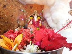 a metal bowl filled with flowers on top of a table