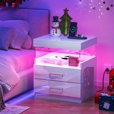 a white night stand with christmas decorations on it and a snowman decoration in the background