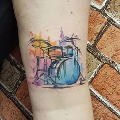 a watercolor drum tattoo on the arm