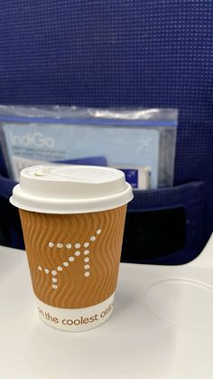 a cup of coffee sitting on top of a table next to a blue folder case