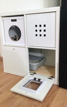 a dog house built into the side of a wall with its door open to reveal a litter box