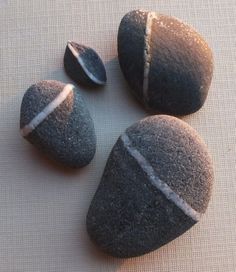 four black rocks with white stripes on them