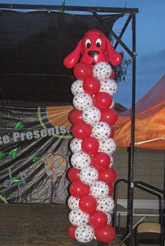 the balloon dog is on display in front of an outdoor tent for people to see