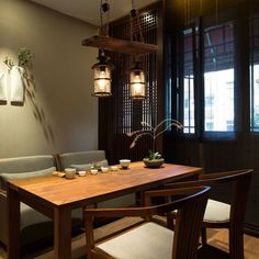 a wooden table sitting under two hanging lights