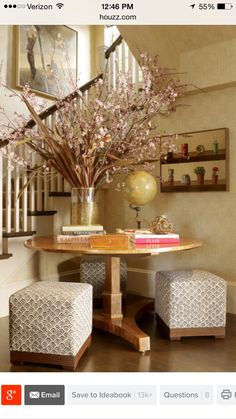 a table with two chairs and a vase filled with pink flowers on top of it