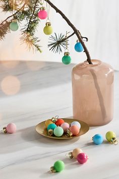 a vase filled with ornaments sitting on top of a table next to a small plate