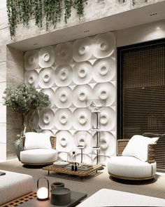 a living room with white furniture and plants on the wall