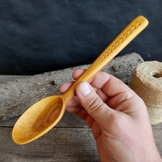 a person holding a wooden spoon in their hand