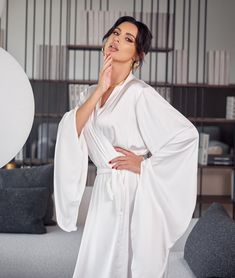 Bridal robe with wide sleeves Do you want to look irresistible in your pre-wedding photos? Or surprise everyone with your great look? You are now looking at a wonderful robe that is designed to make you truly irresistible! This is exactly that highlight that is needed for the bride's morning to be completely successful. Or not the bride's morning, but every morning of any day!        This robe of incredible beauty will raise your status both in your own eyes and in the eyes of everyone around yo Elegant White Floor-length Kimono, White V-neck Robe For Sleep, Long Wedding Robe With Satin Finish, Elegant V-neck Kimono For Wedding, Elegant V-neck Wedding Kimono, White Satin Finish Dress For Wedding Night, Elegant White Satin Finish Gown, White Kimono Sleeve Dresses For Loungewear, Elegant Floor-length Sleepwear