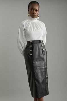 Experience Sleek Tailoring With Our Leather Pencil Skirt. Made With Supple Leather Fabric, A Tailored Fit And Military Button Detail, This Verstaile Midi Skirt Can Take You From Day To Night. Style With Knitwear Or Basic T-Shirt And Flats For A More Casual Look, Or Dress It Up With A Blouse And Heels. Leather Military Button Pencil Midi Skirt High Quality, Soft Real Leather Comfortable High Waistline Belt Loop Features Flattering Tailored Fit Military Button Detail Midi Length Petite Wedding Guest Dresses, Sequin Coats, Black Experience, Plus Size Workwear, Pencil Midi Skirt, Pencil Skirt Outfits, Night Style, Petite Coat, Office Siren