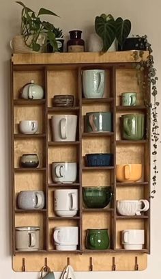 a wooden shelf filled with lots of cups and saucers