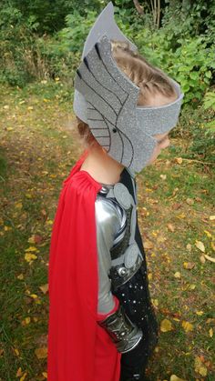 a little boy dressed up as thor from the avengers movie wearing a helmet and cape